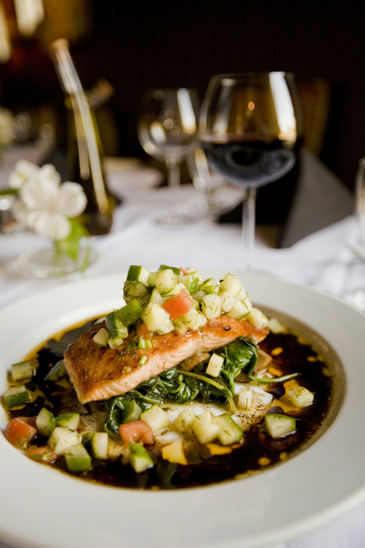 Seared salmon plated over greens at a white-tablecloth restaurant