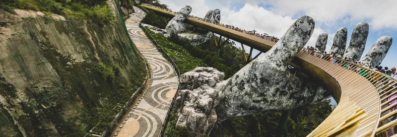 Panoramic view of the Golden Bridge and its stone hands snaking along a forested ridge