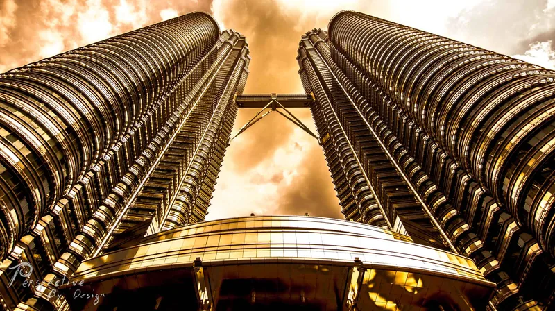 The Petronas Towers photographed from directly below, twin steel spires converging into the sky
