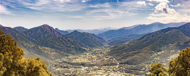 A broad green valley opening between the Rif mountains, a white town scattered across the slope