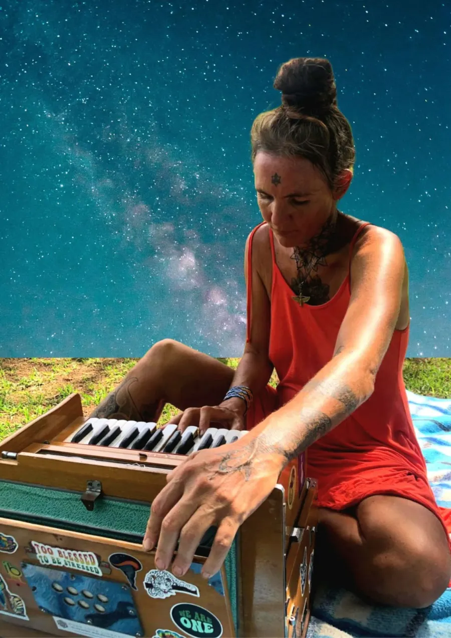 Issa Karuna playing the harmonium under a night sky